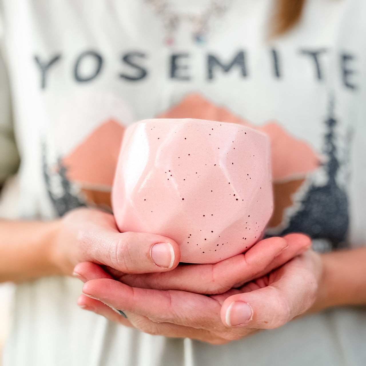 a woman holding a pink cup in her hands