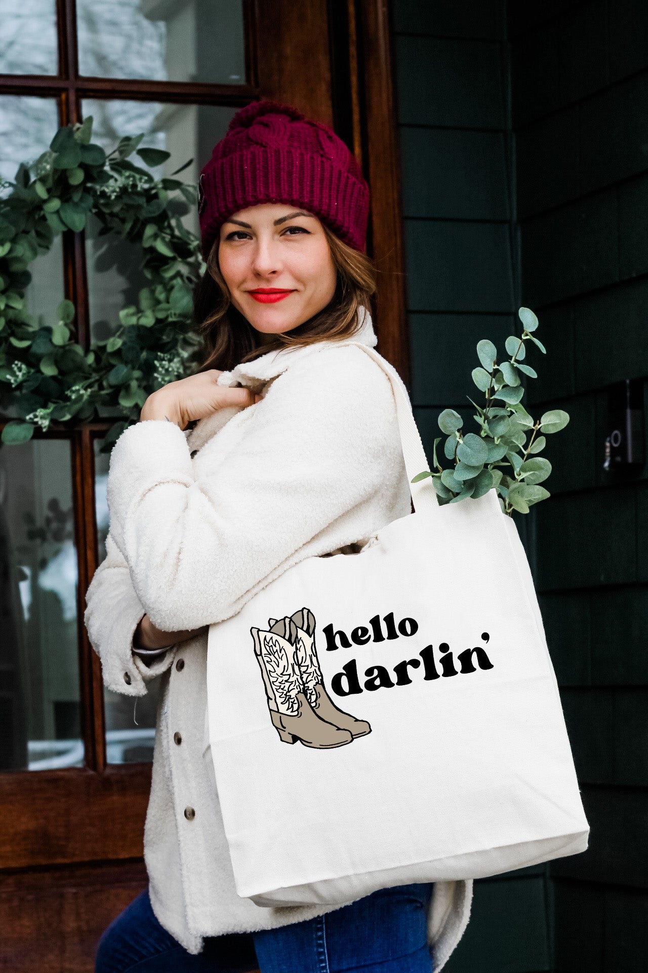 a woman carrying a hello darfin shopping bag