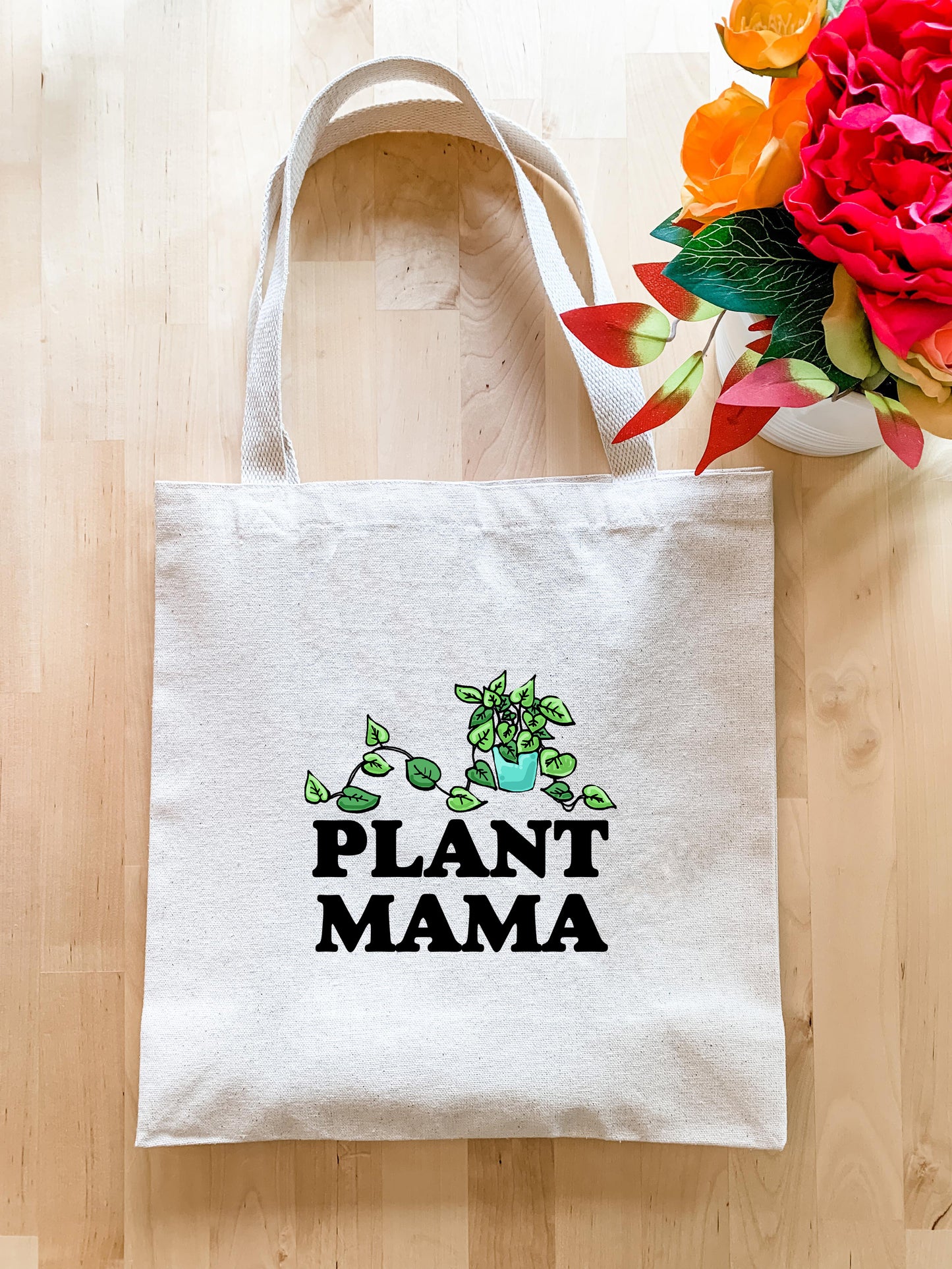 a plant mama tote bag next to a bouquet of flowers