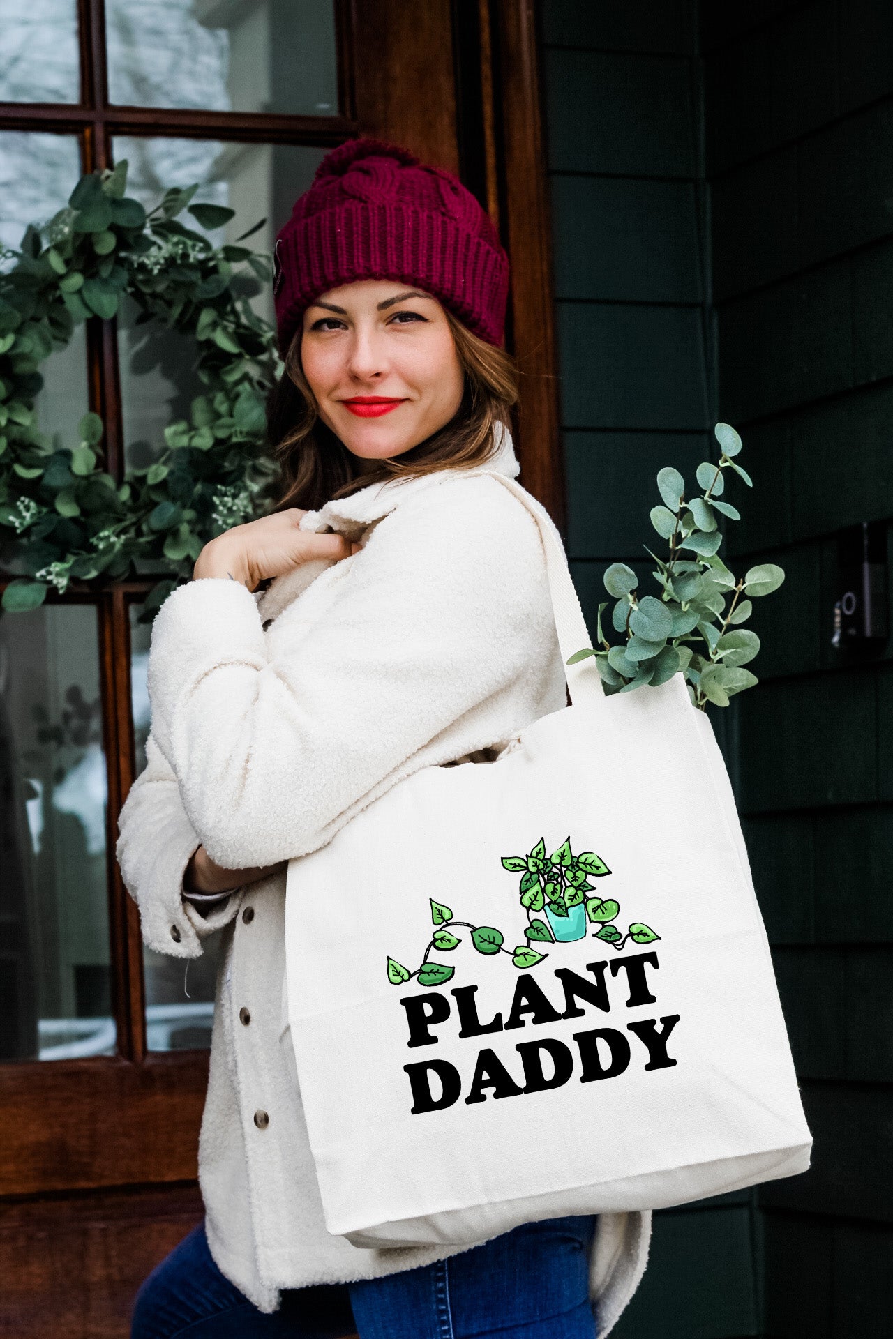 a woman carrying a bag that says plant daddy