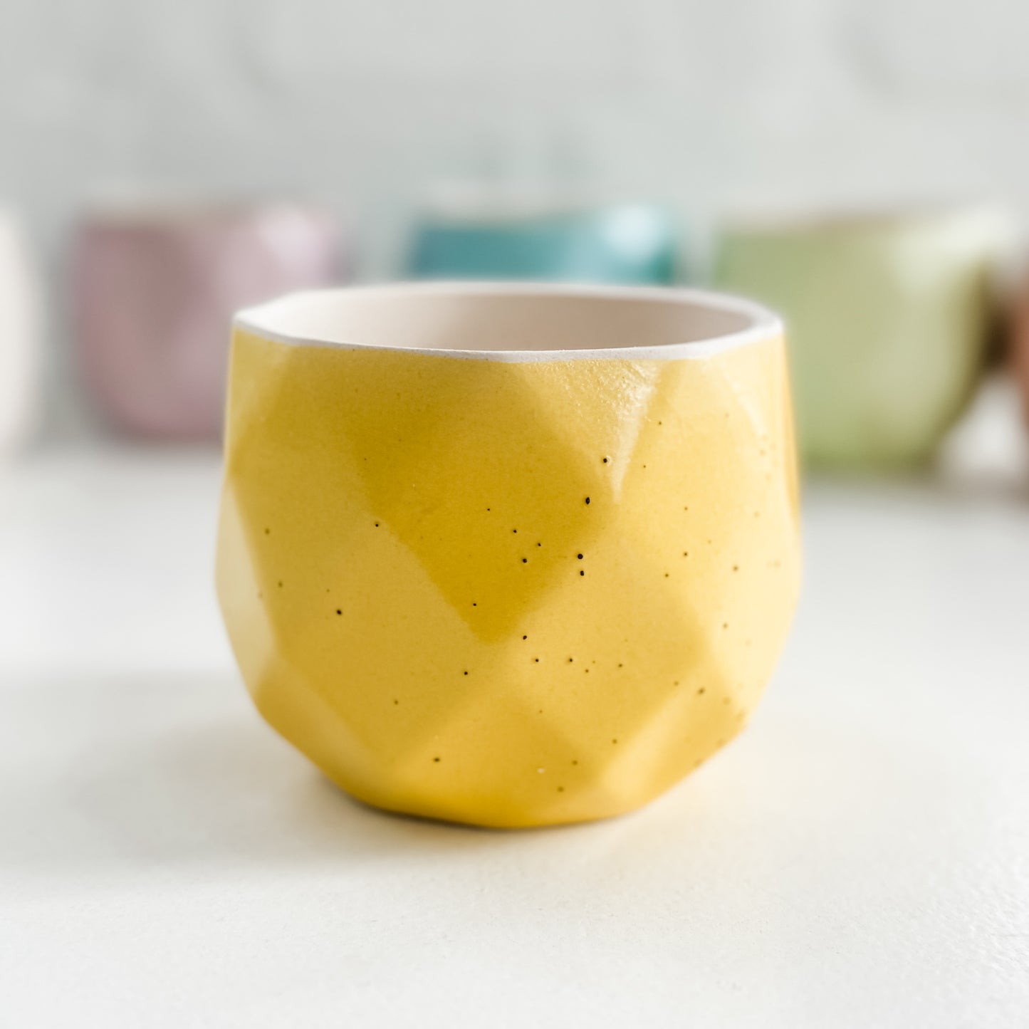 a yellow bowl sitting on top of a white table