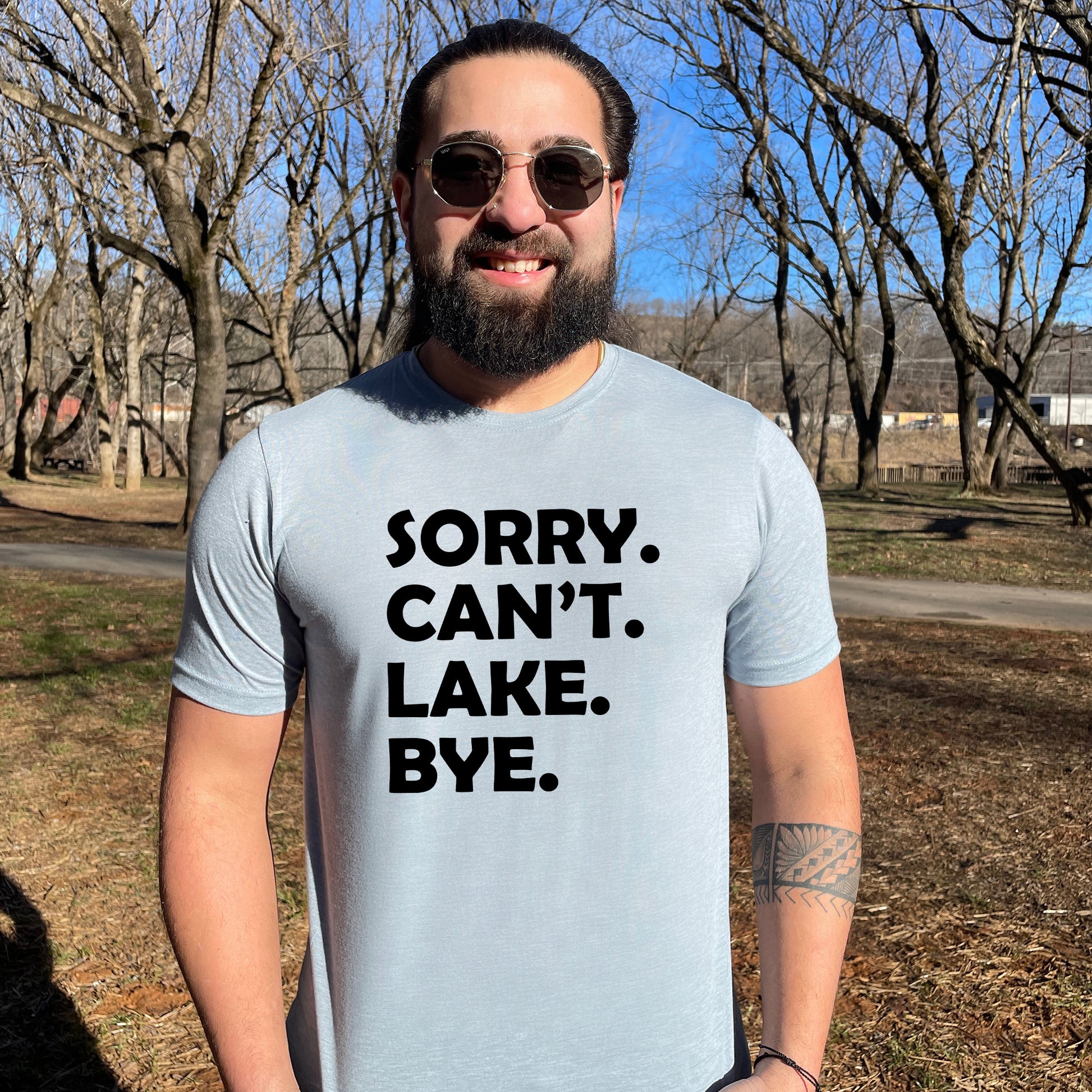 a man wearing a t - shirt that says sorry can't lake bye