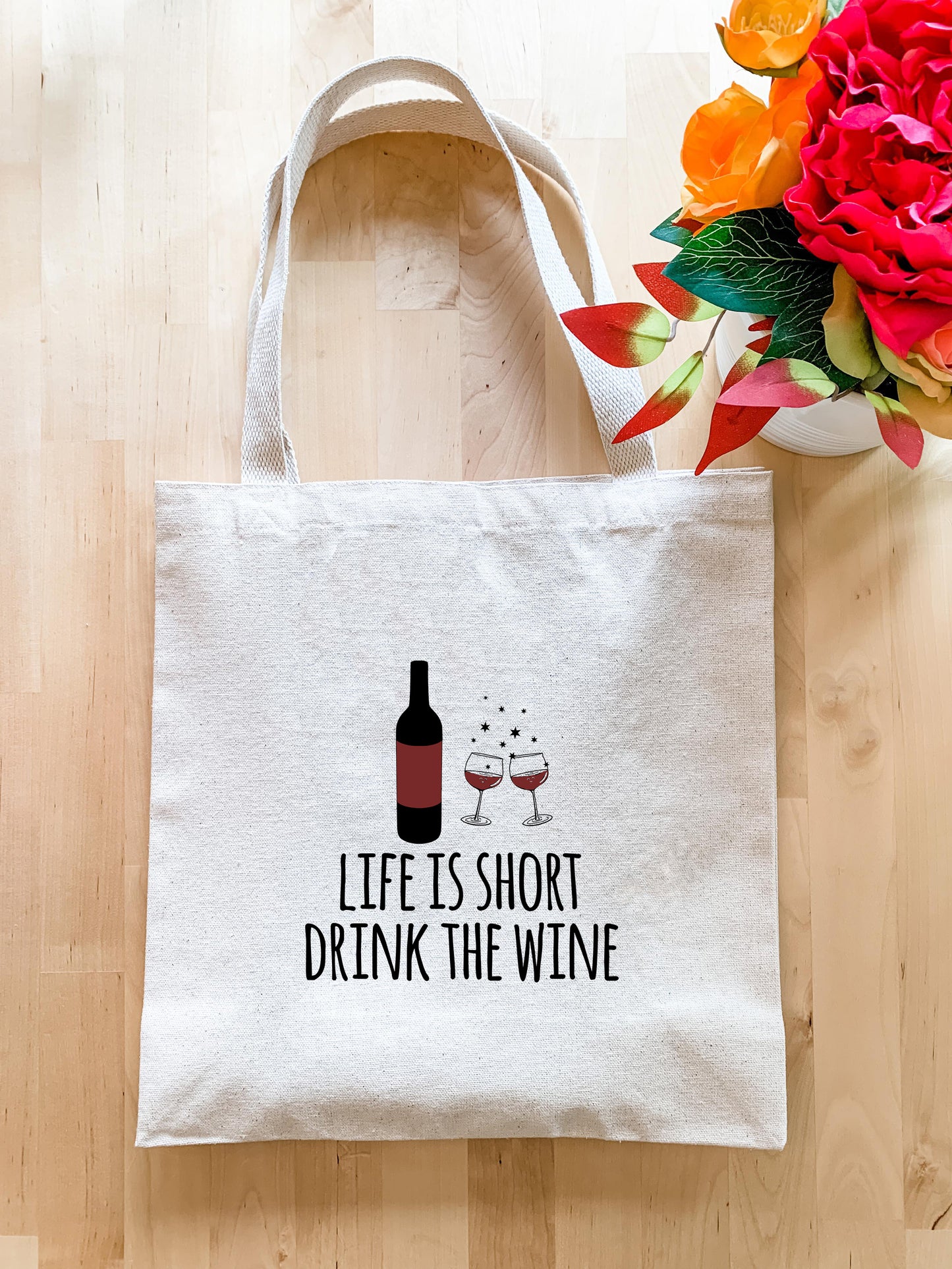 a tote bag with a bottle of wine and a vase of flowers