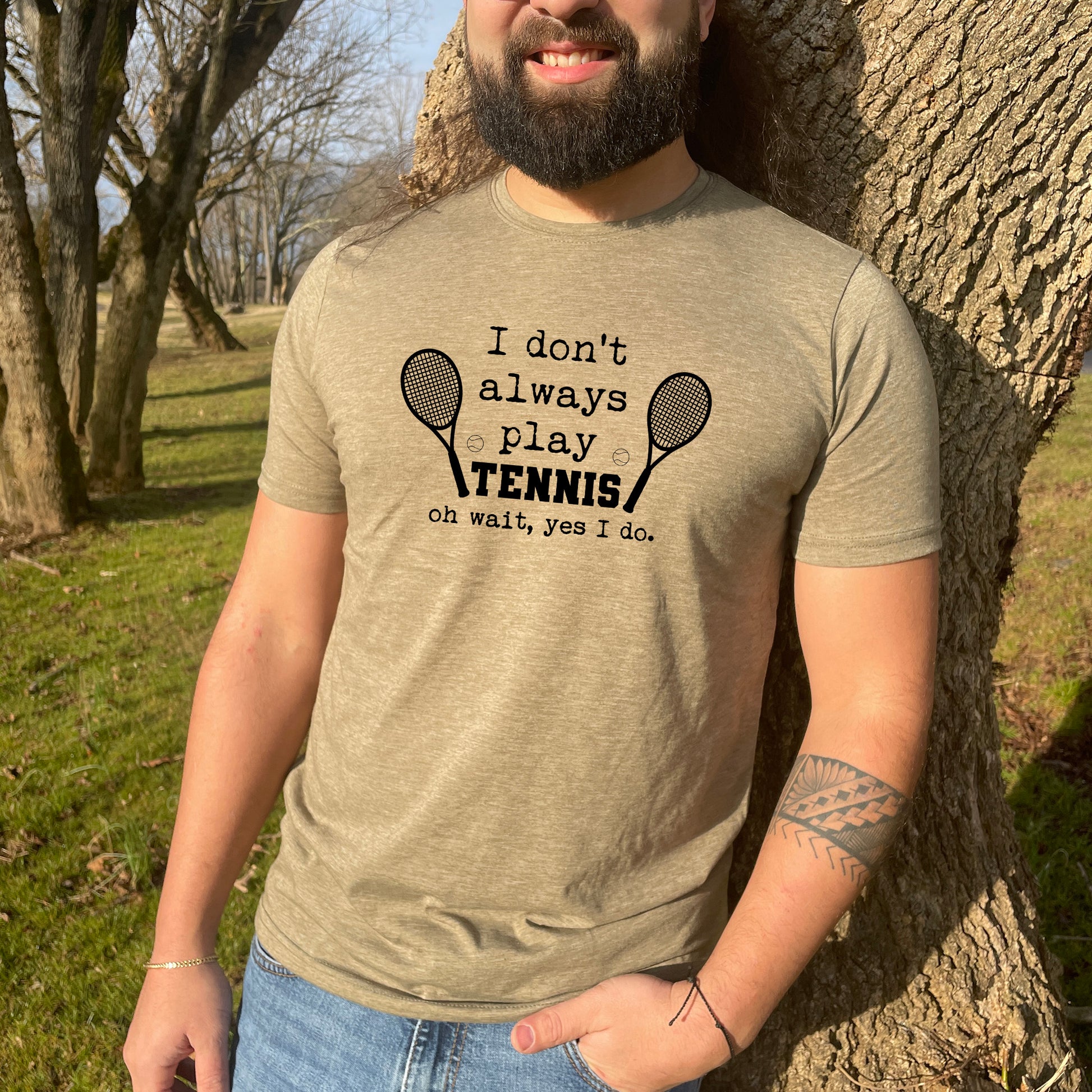 a man standing next to a tree with a tennis racket on it