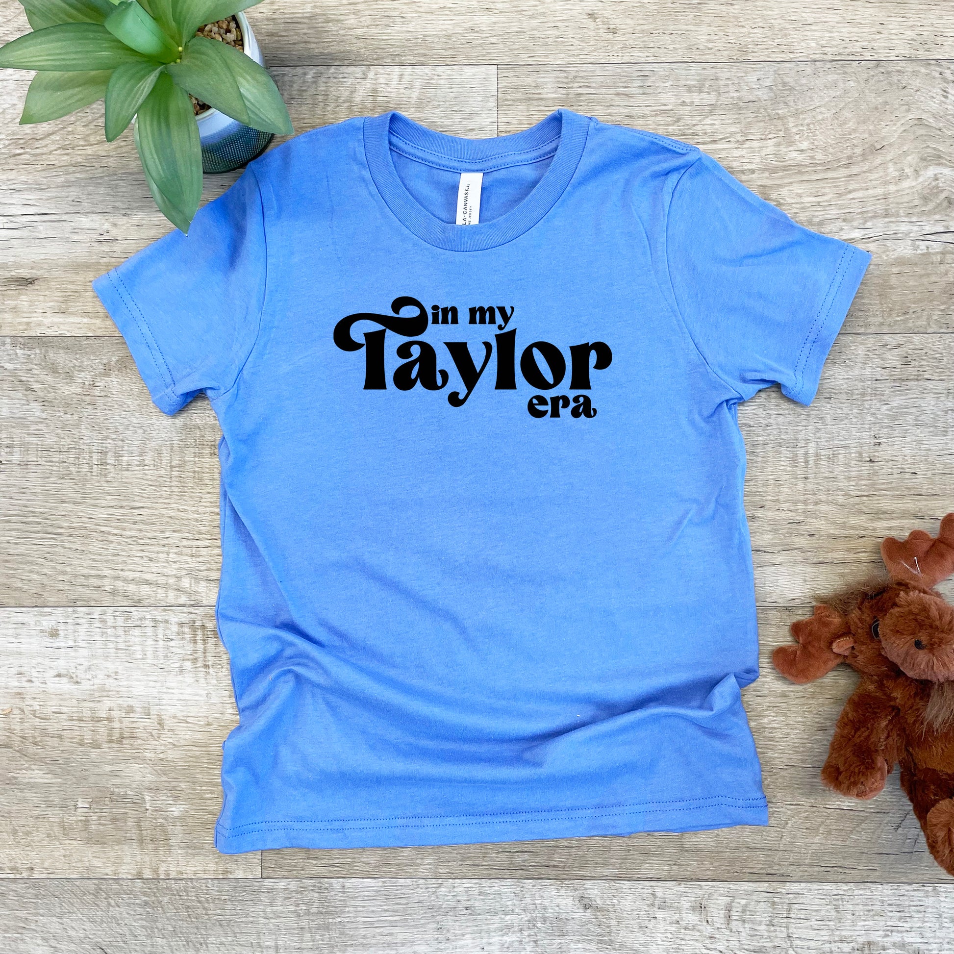 a blue shirt that says on my taylor era next to a teddy bear