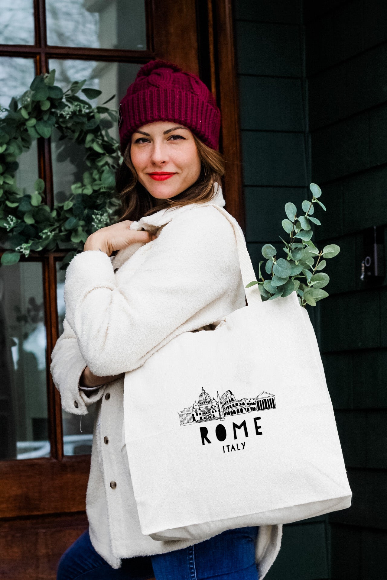 a woman carrying a white bag with the word rome on it