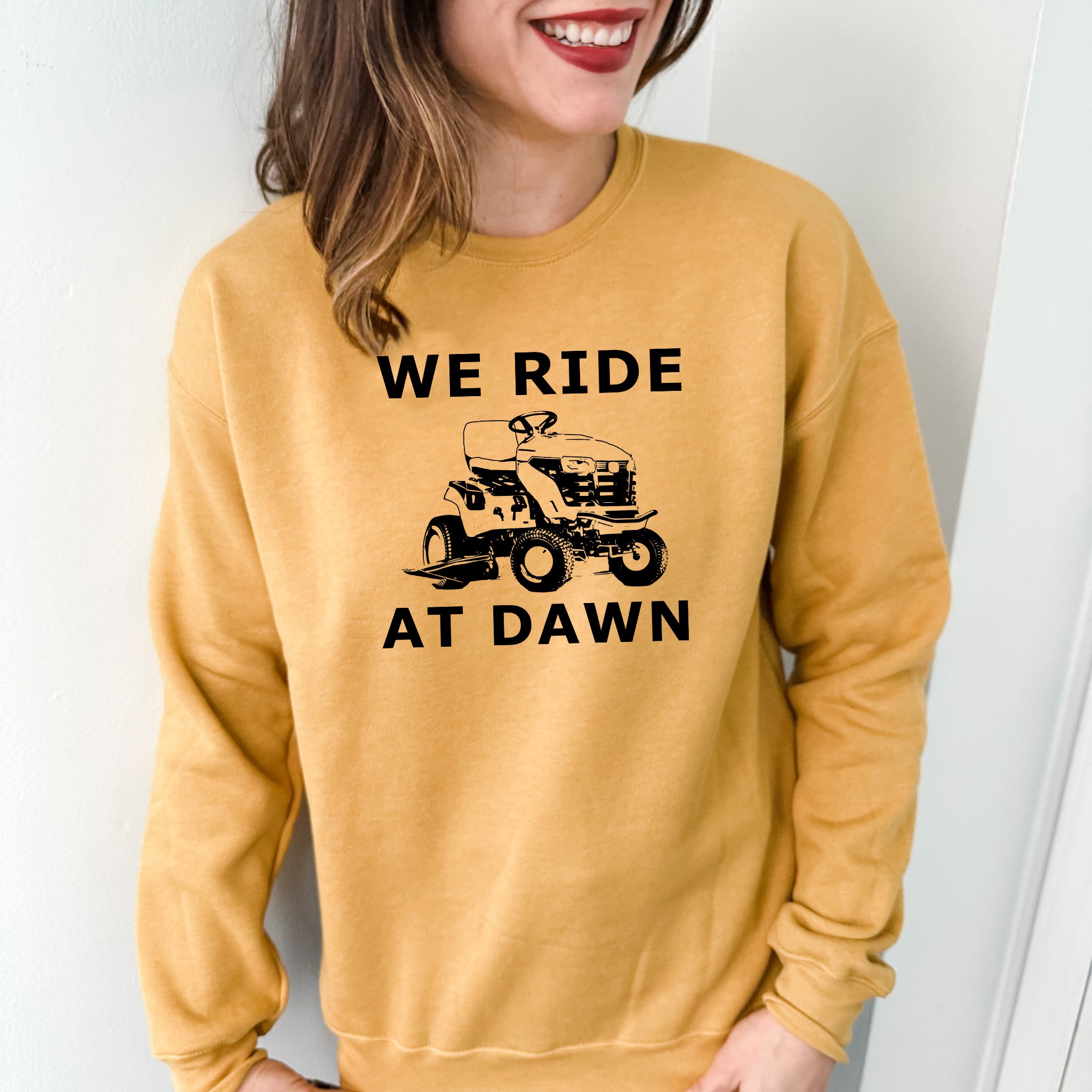 a woman wearing a sweatshirt that says we ride at dawn