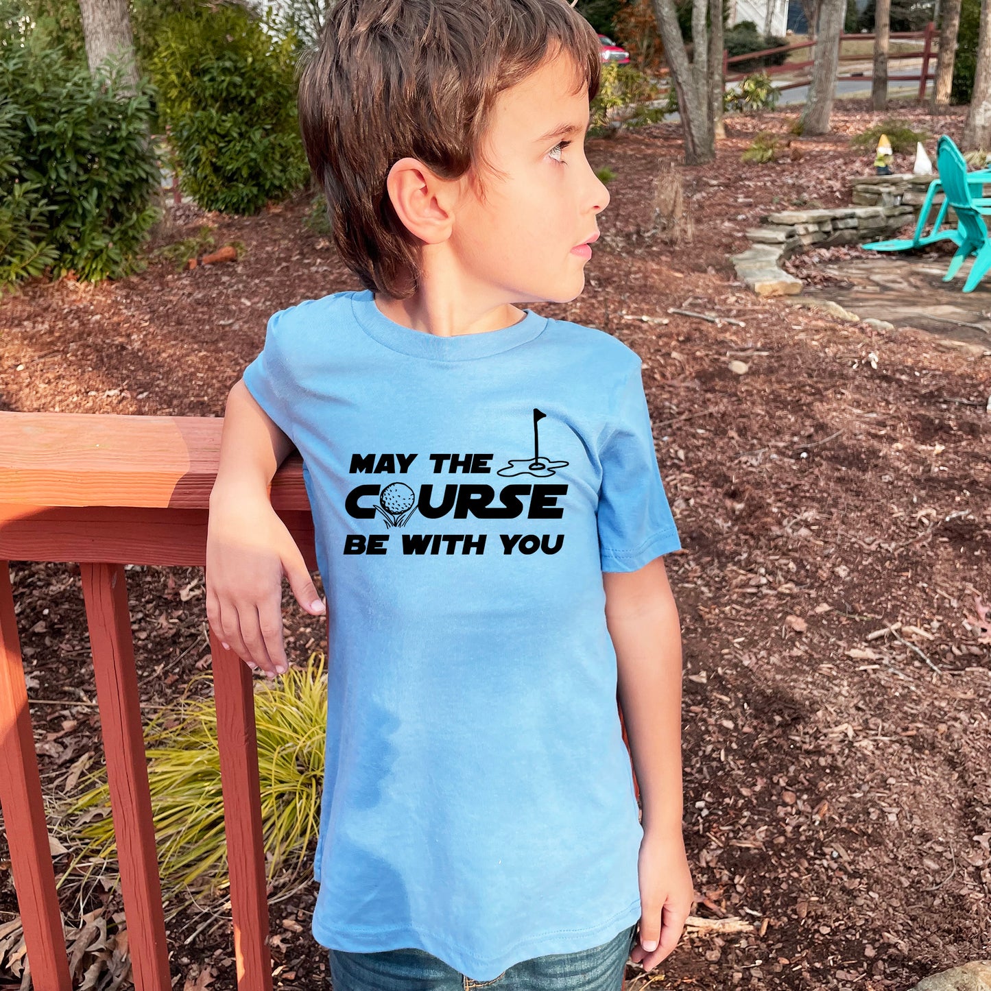 a young boy wearing a blue shirt that says may the course be with you
