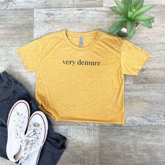 a t - shirt that says very demure next to a pair of jeans