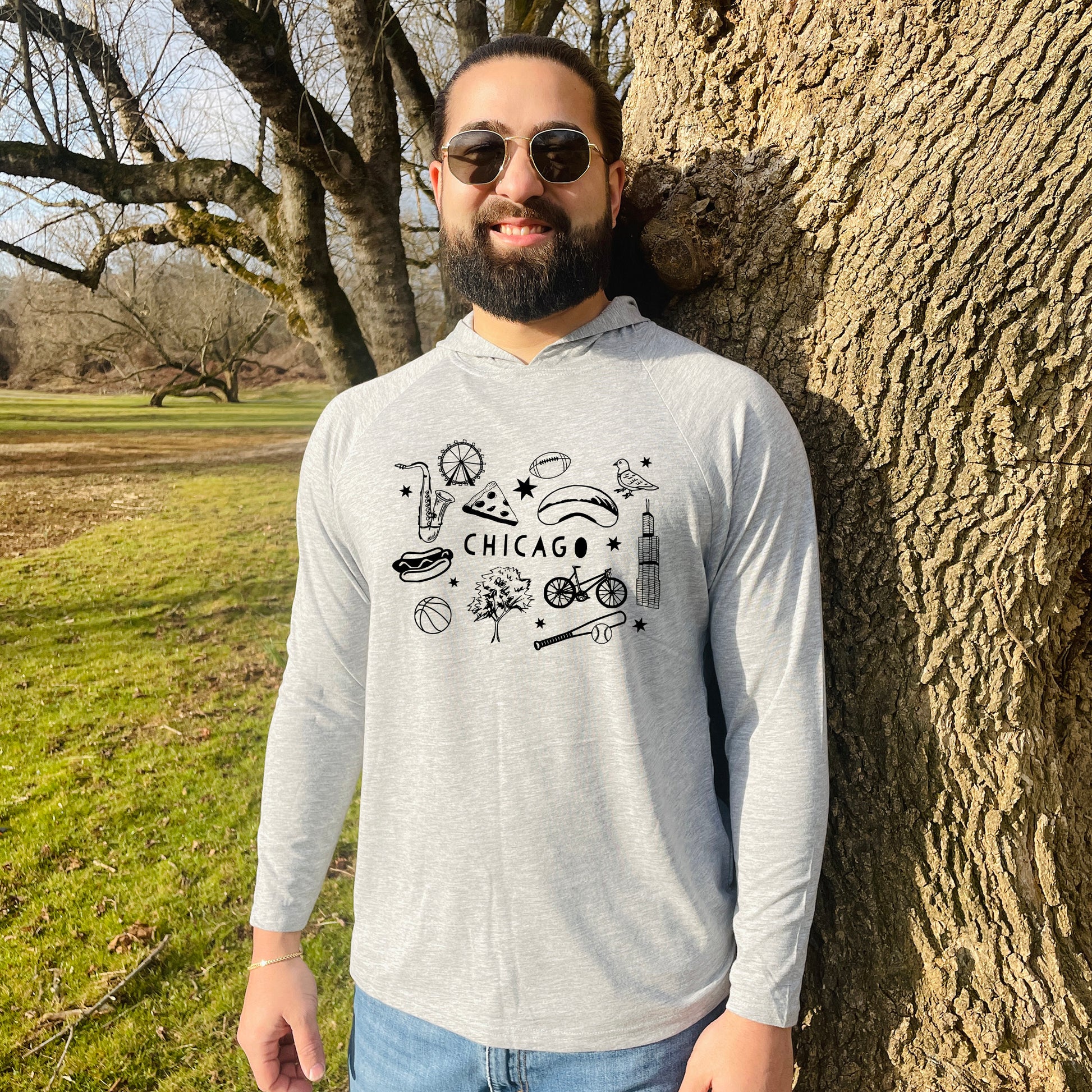 a man standing next to a tree in a park