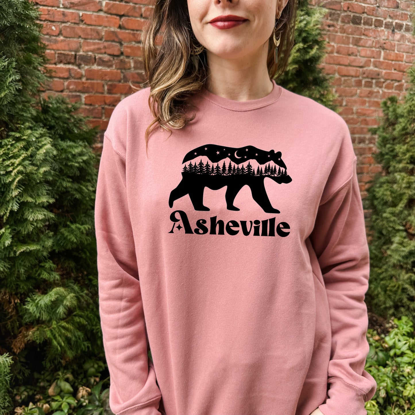 a woman wearing a pink sweatshirt with a bear on it