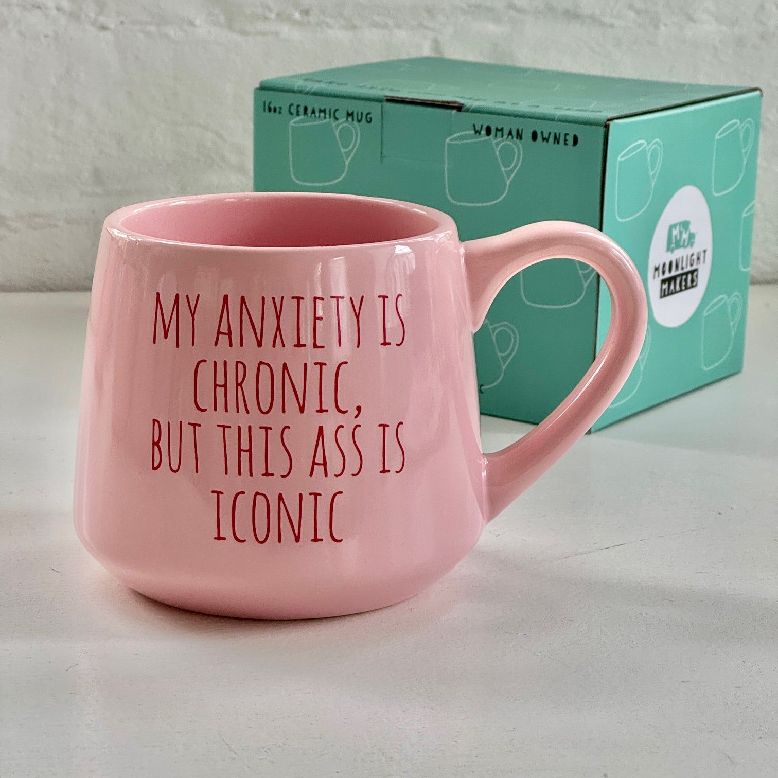 a pink coffee mug sitting next to a box of tissues