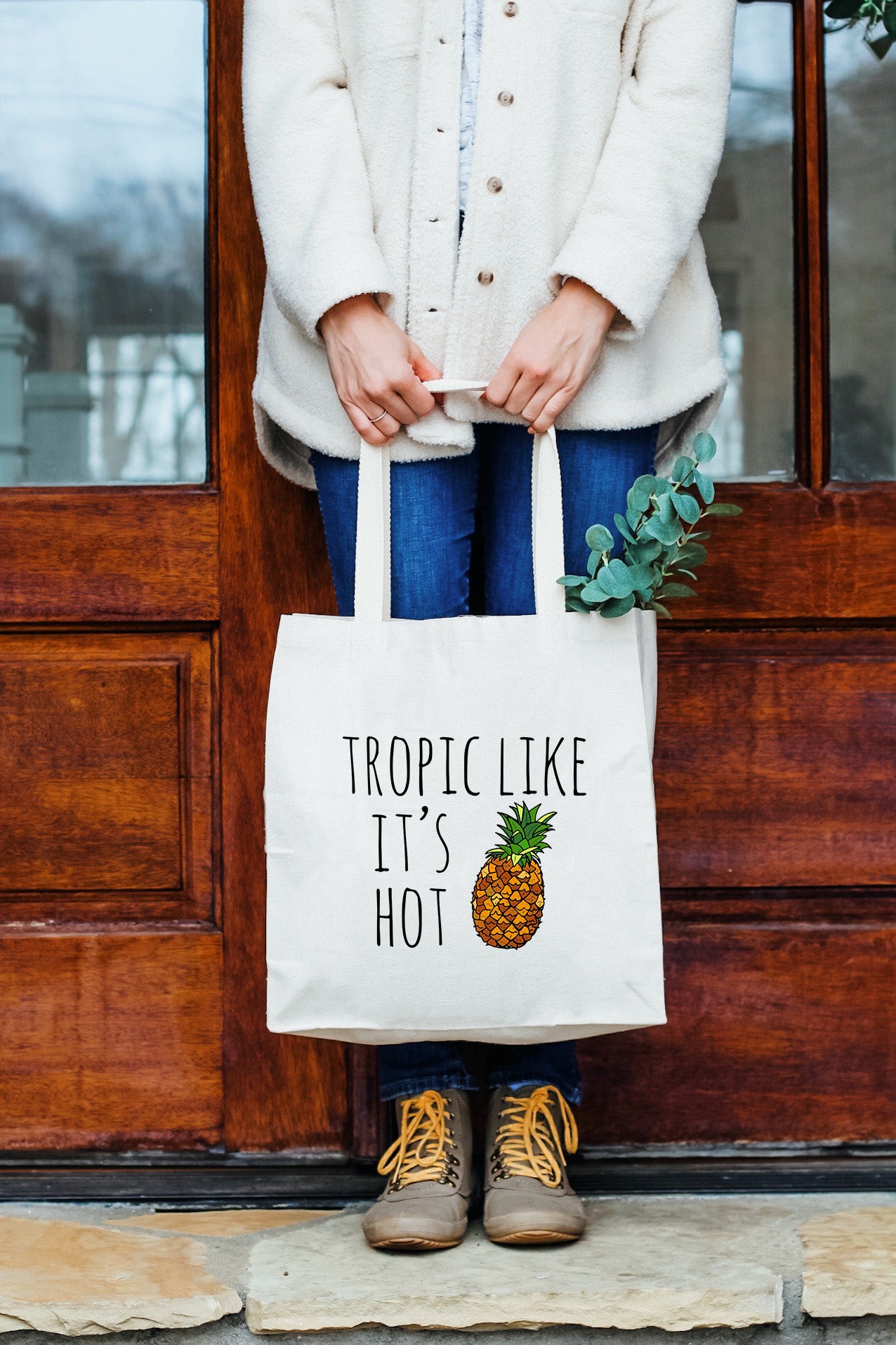 a woman holding a bag that says tropical like it's hot