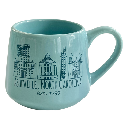 a blue coffee mug with a city skyline on it