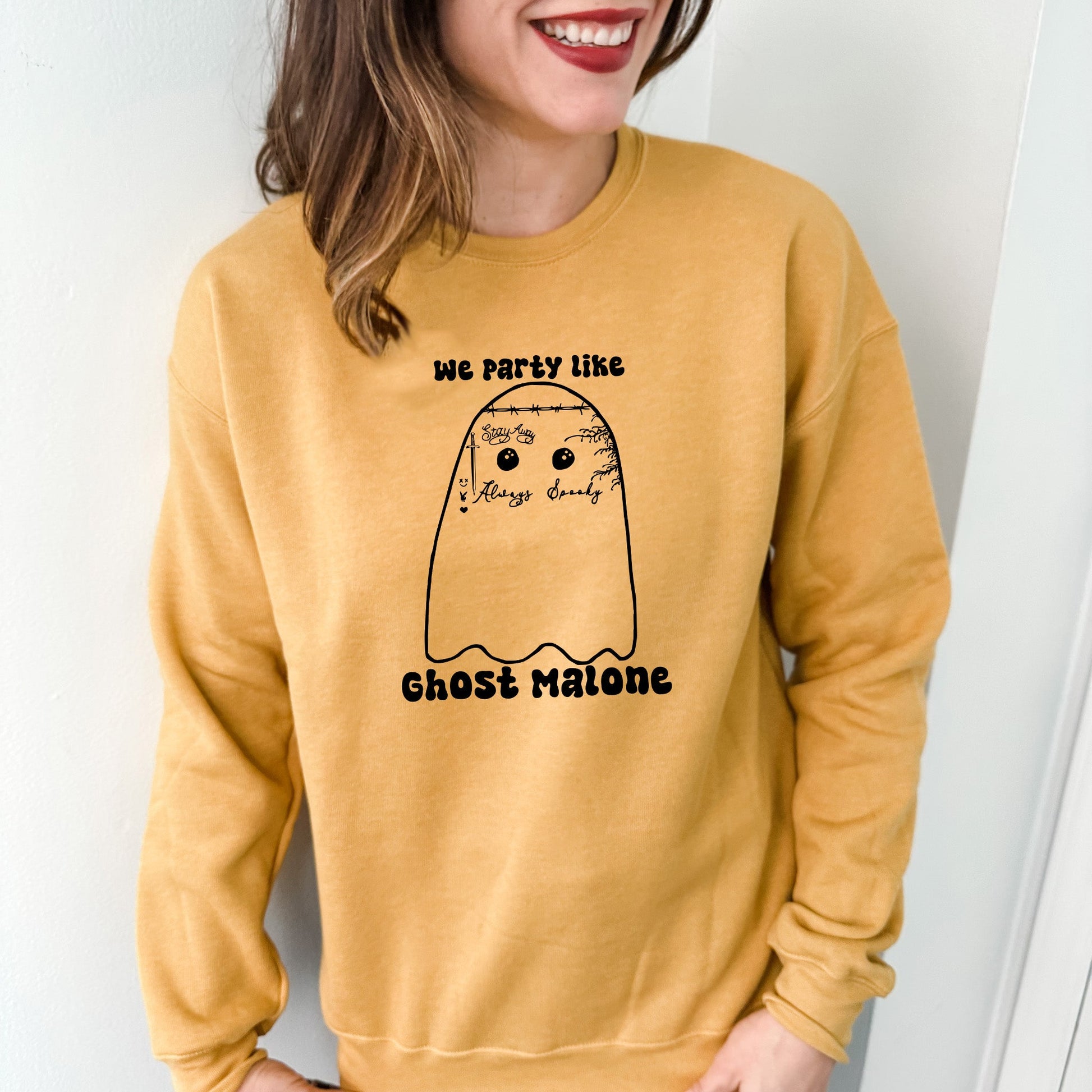 a woman wearing a yellow sweatshirt with a ghost on it