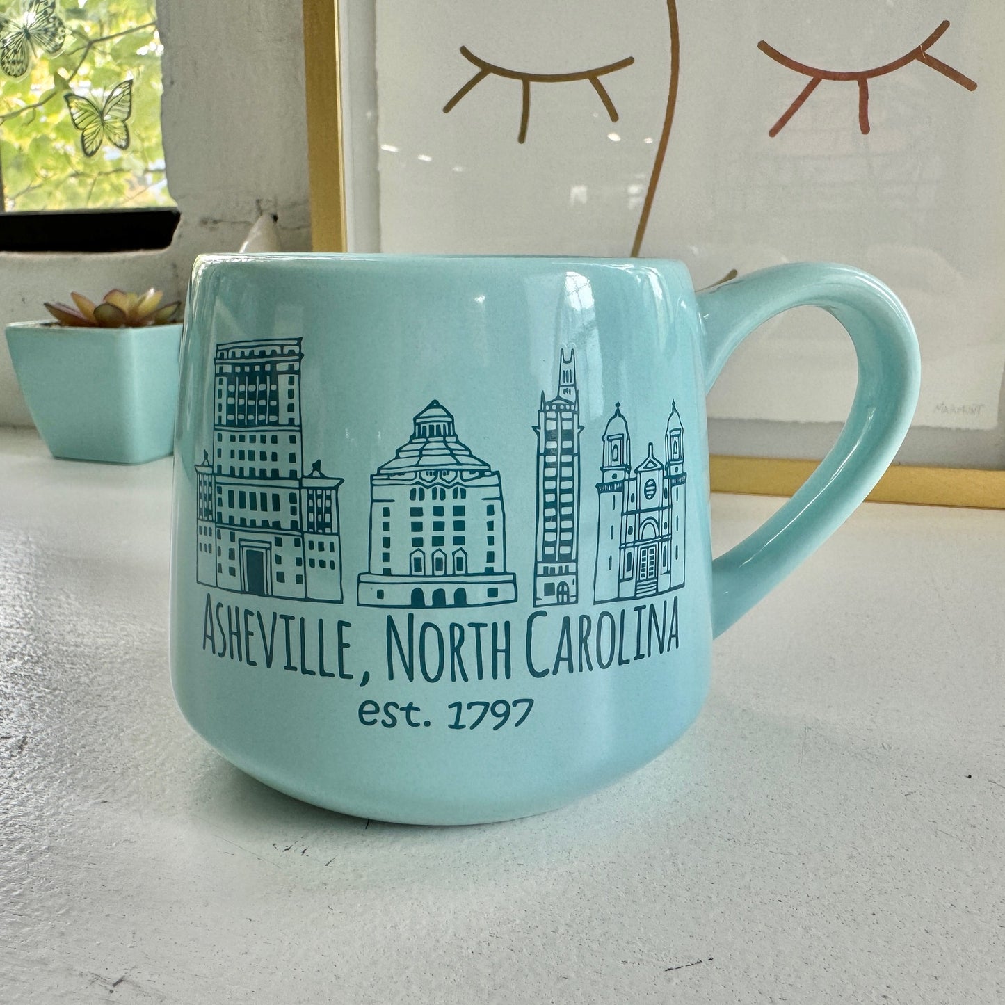 a blue coffee mug with a picture of a city in the background