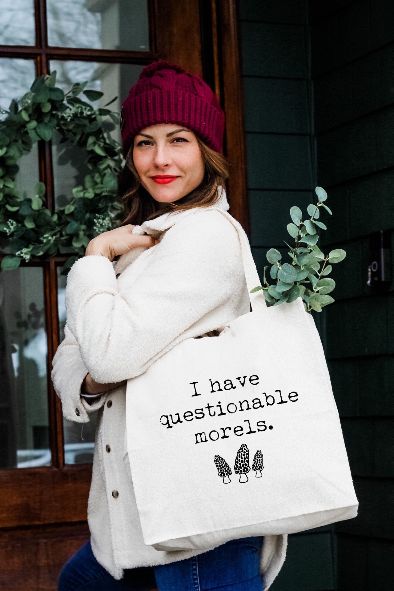 a woman holding a white bag that says i have questioning morels