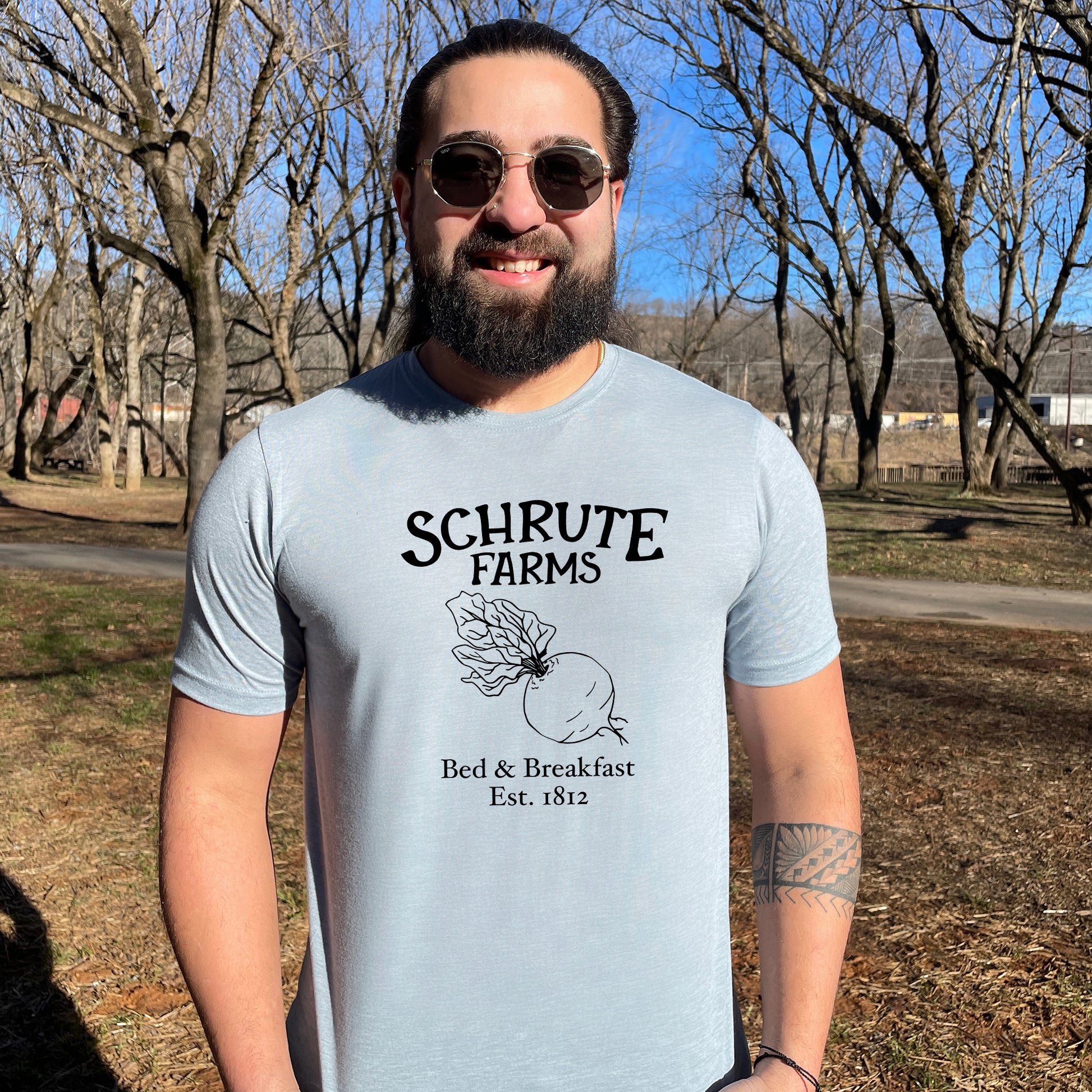 a man with a beard wearing a t - shirt that says schrute farms