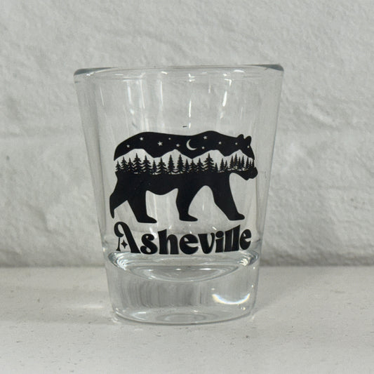 a glass with a bear and trees on it