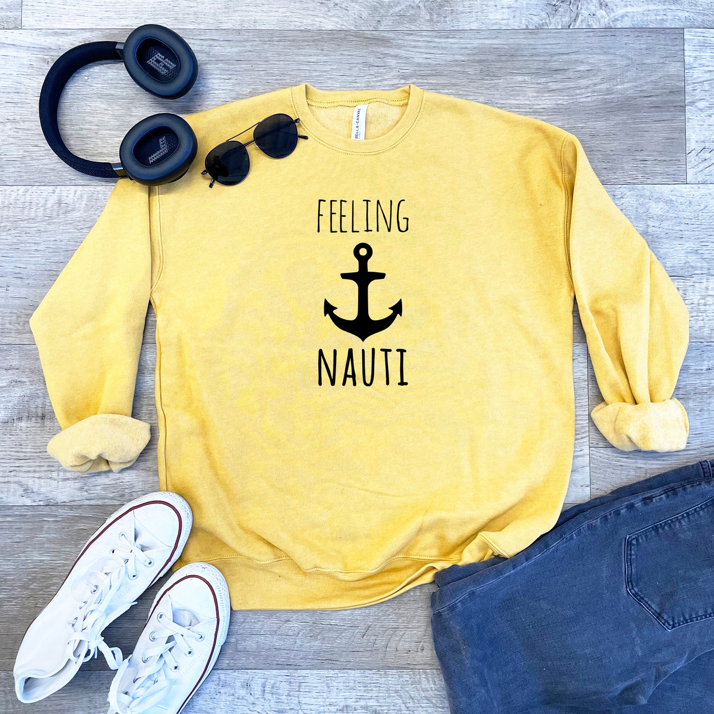 a yellow sweatshirt with a black anchor and a pair of headphones