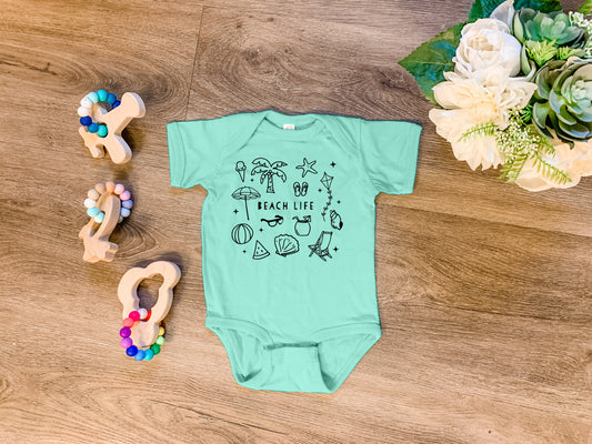 a baby's bodysuit and some toys on a table