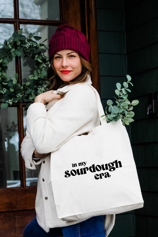a woman carrying a white bag with the words on it