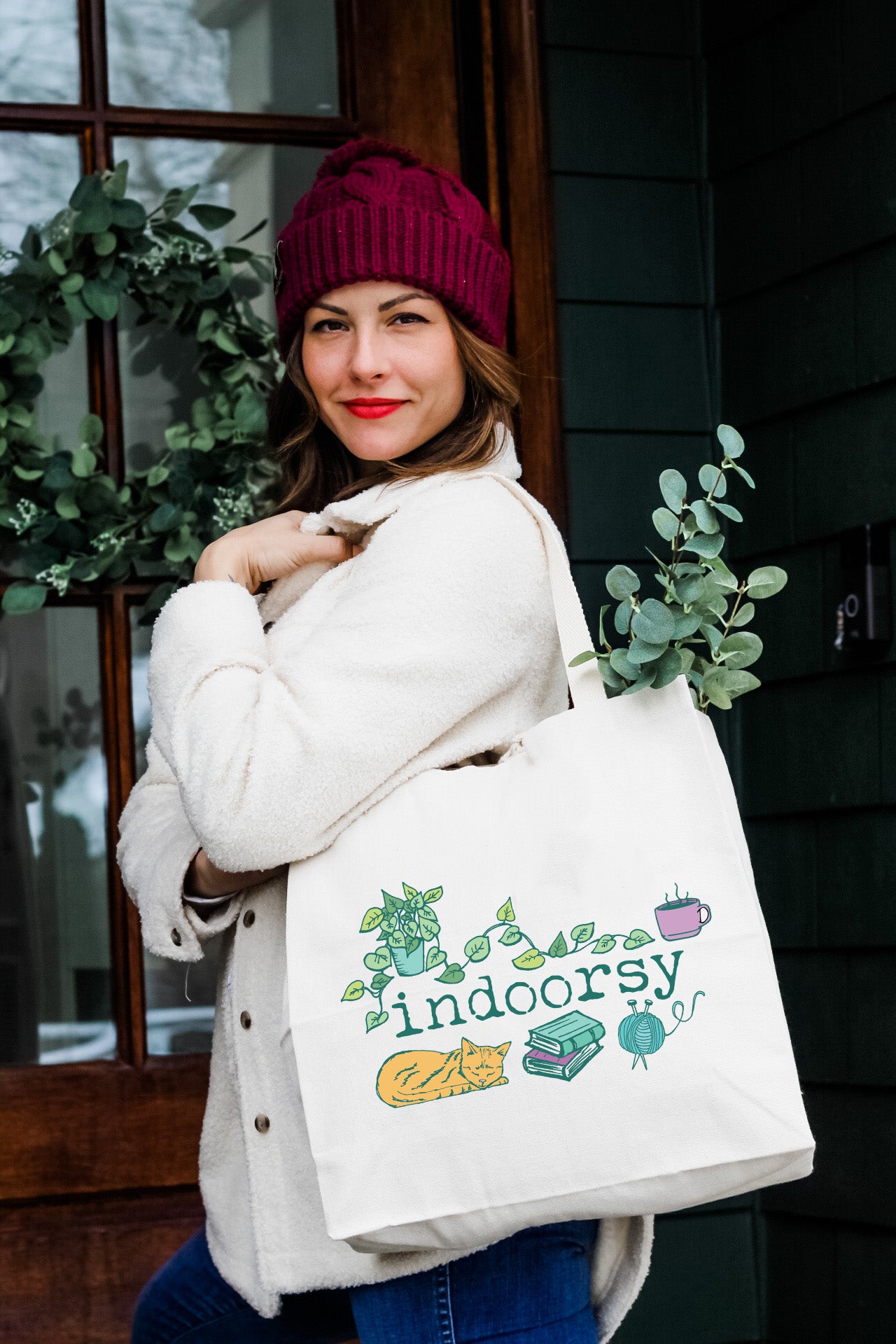 a woman carrying a bag that says indoors