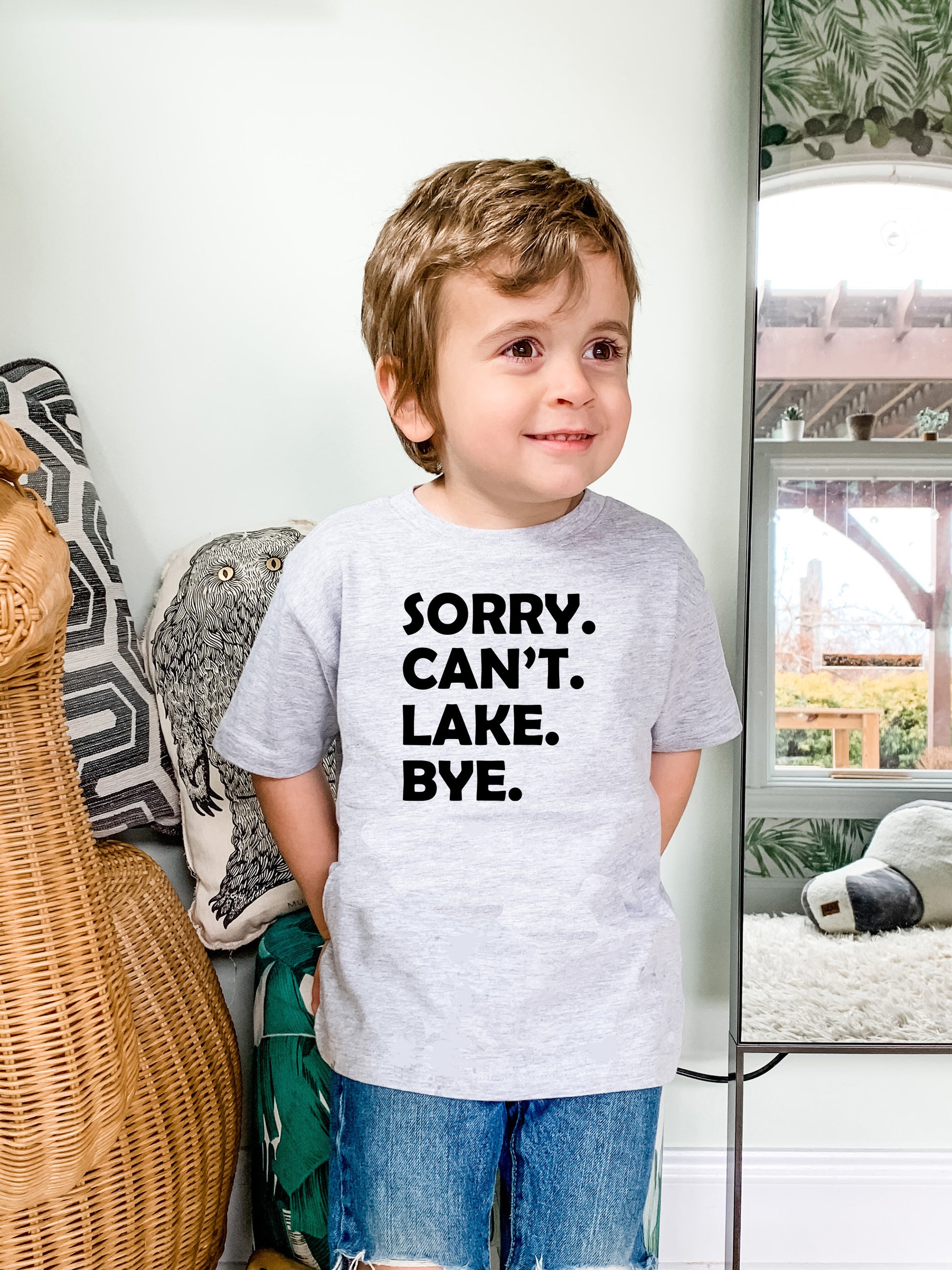 a young boy standing in front of a mirror