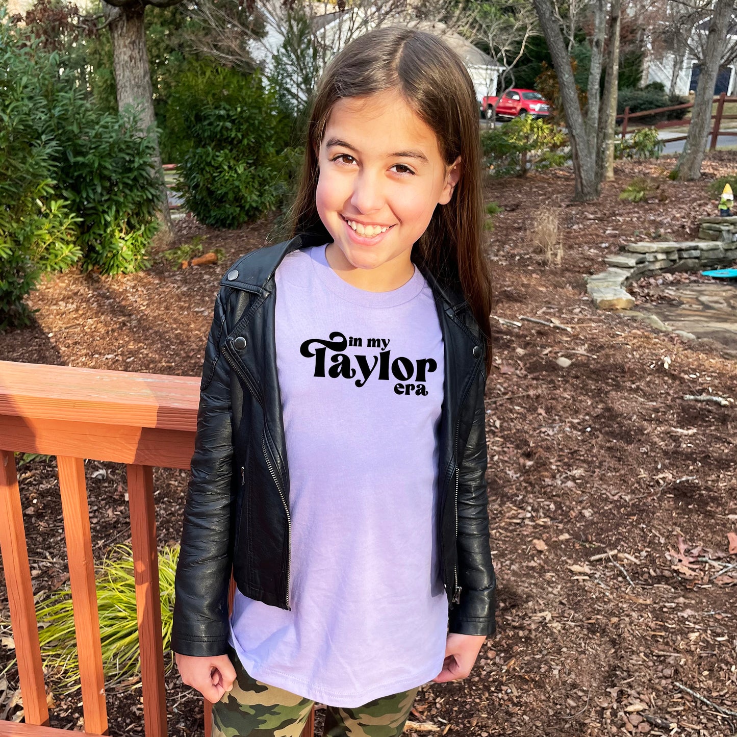 a young girl wearing a purple shirt and black jacket