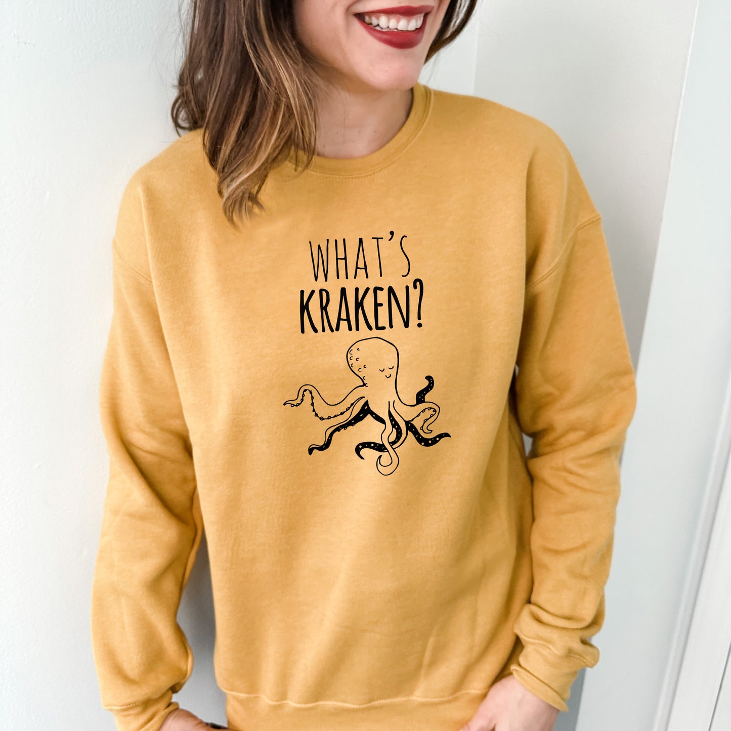 a woman wearing a yellow sweatshirt with an octopus on it