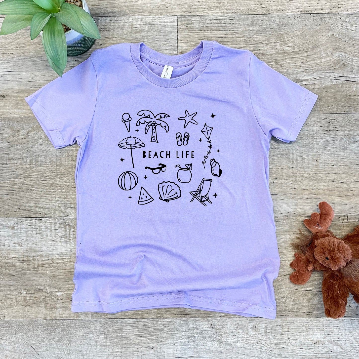 a t - shirt that says beach life on it next to a teddy bear