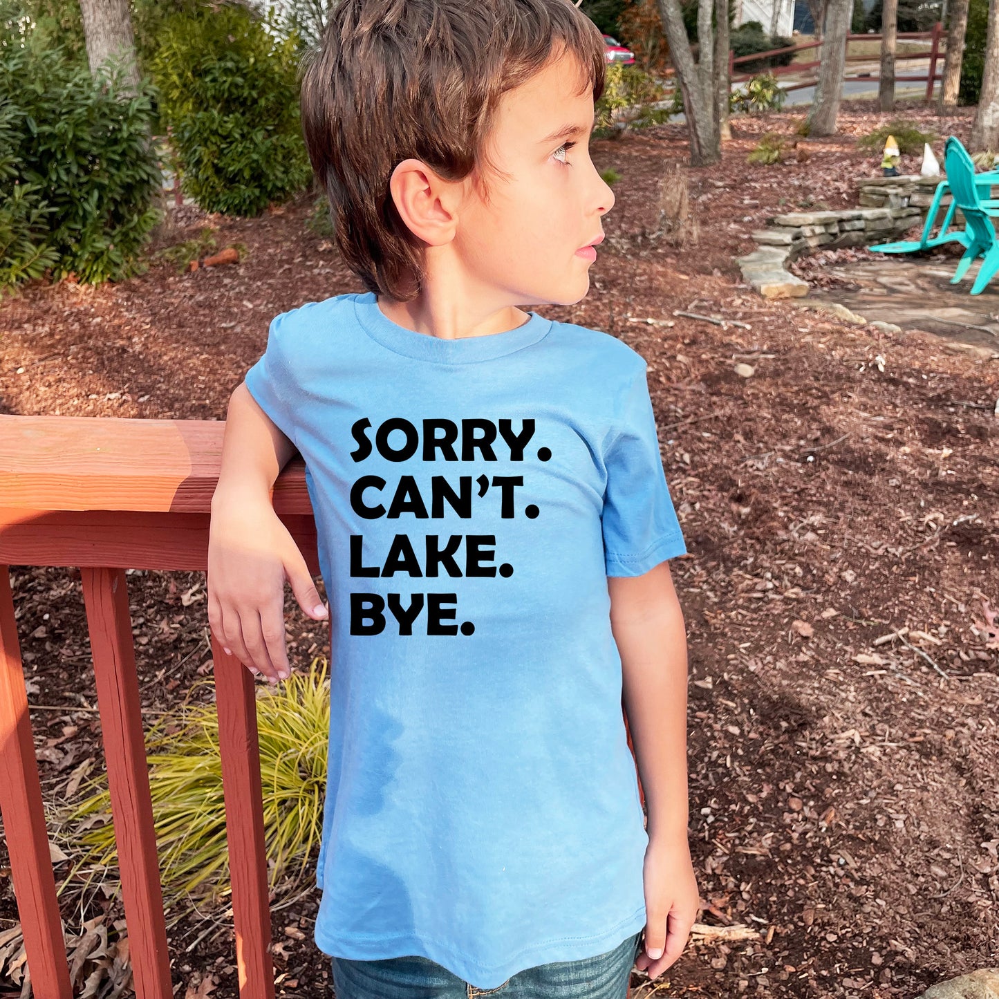 a young boy wearing a blue shirt that says sorry, can't lake bye