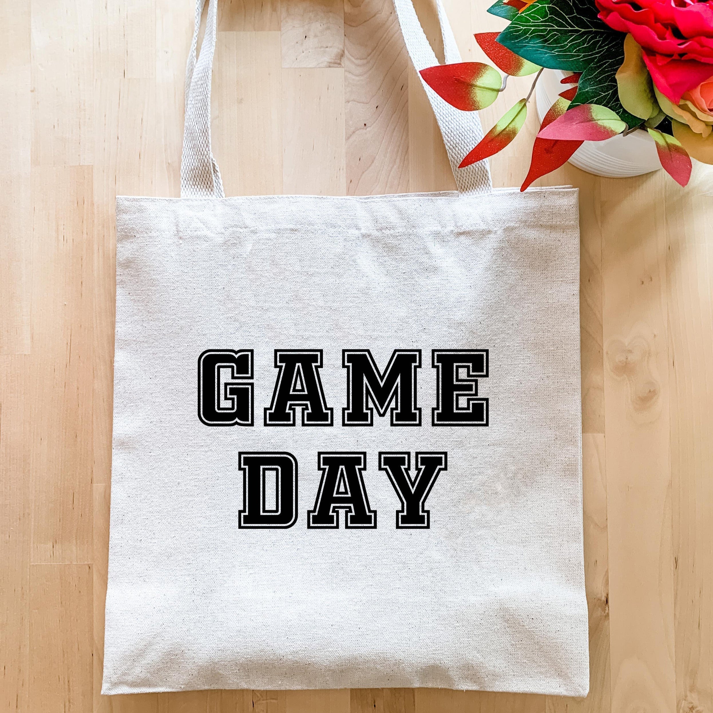 a game day tote bag next to a bouquet of flowers
