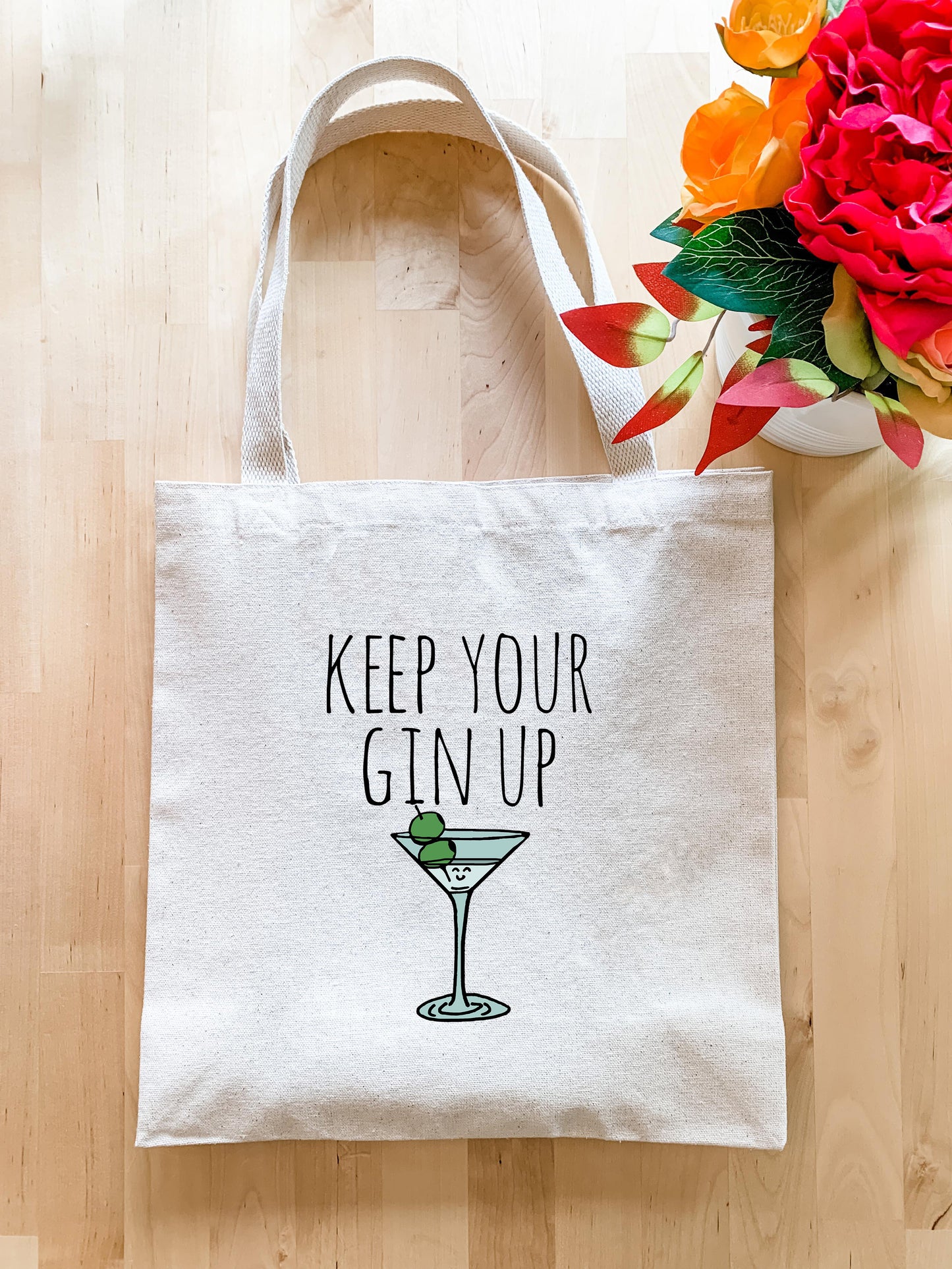 a white tote bag that says keep your gin up