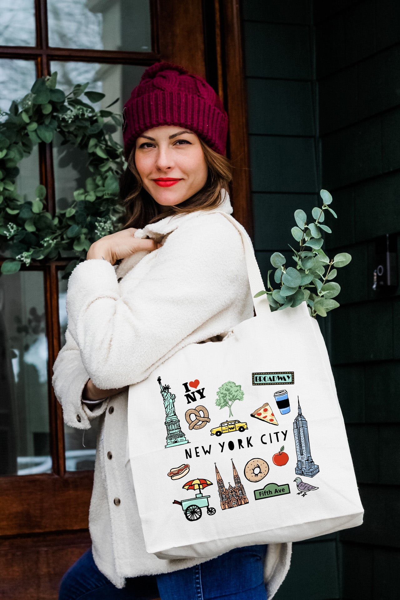 a woman carrying a bag with a picture of new york on it