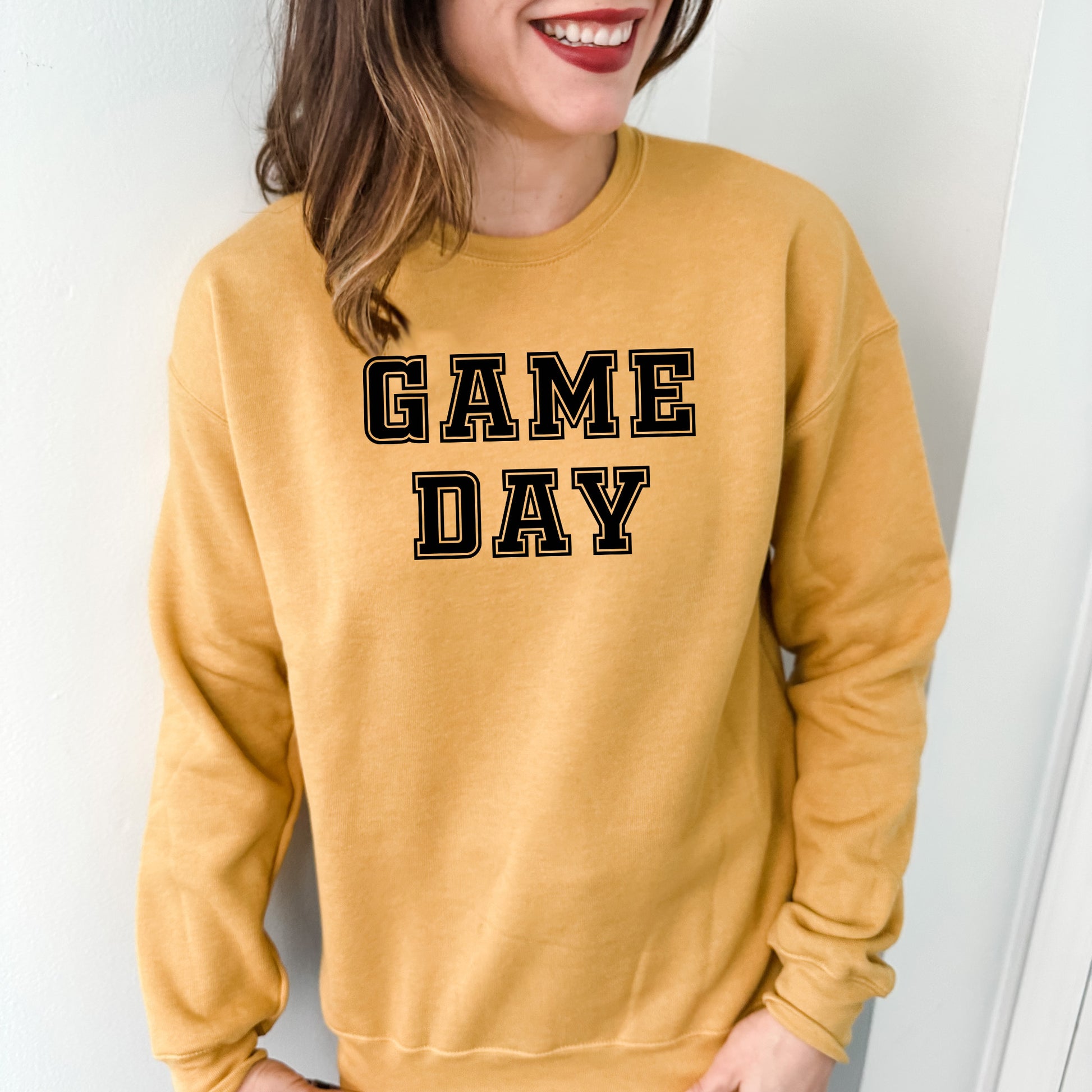 a woman wearing a yellow game day sweatshirt