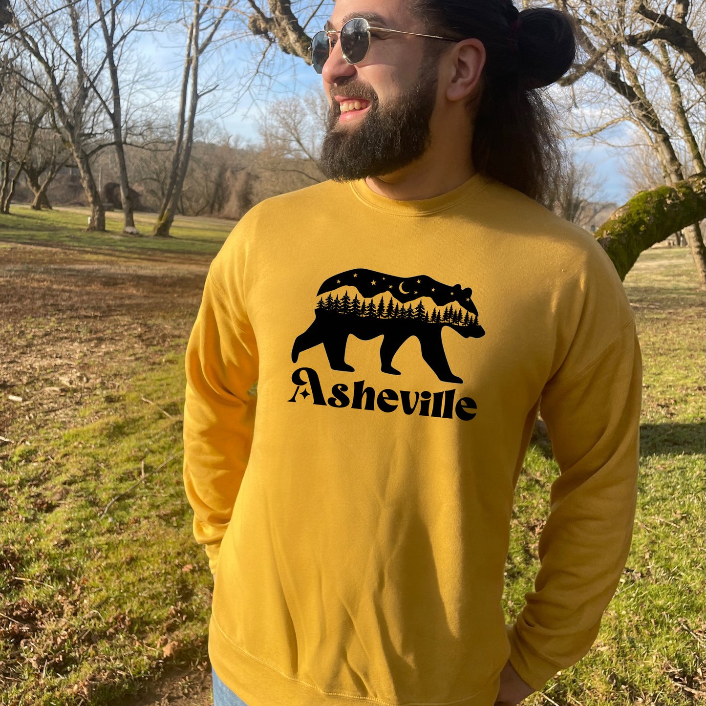 a man wearing a yellow sweatshirt with a bear on it