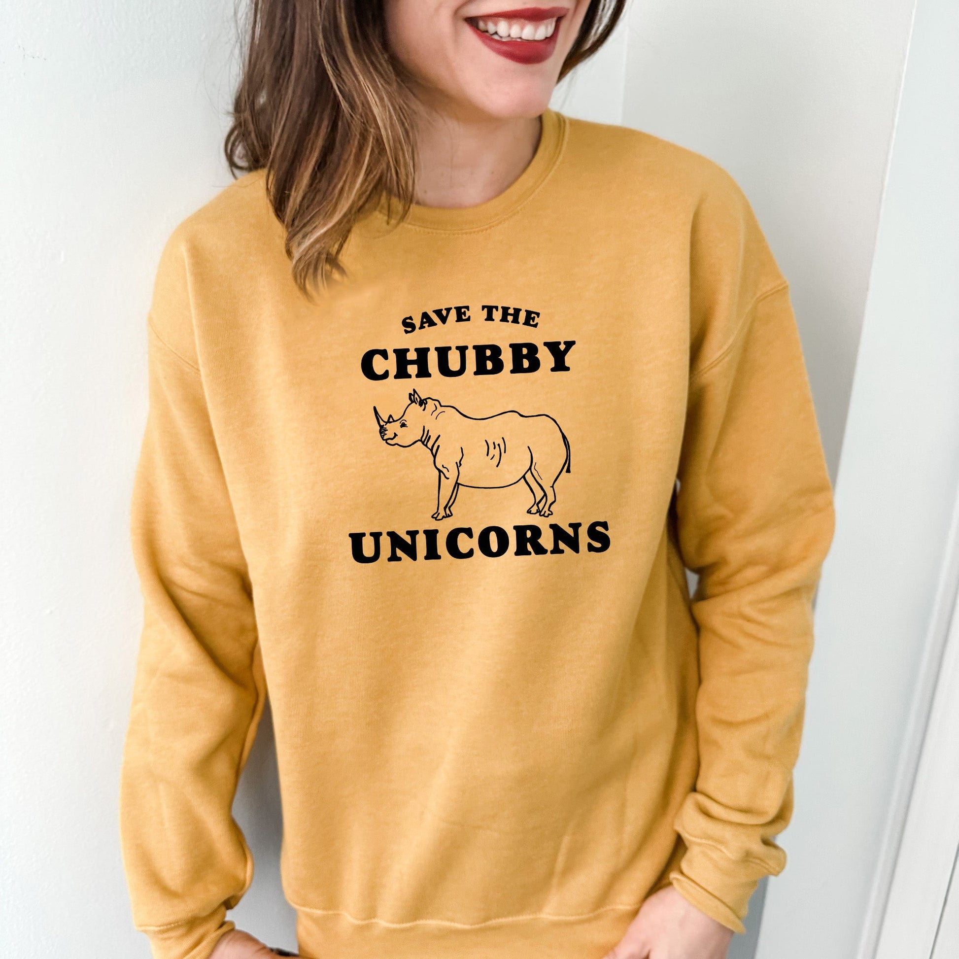 a woman wearing a sweatshirt that says save the chubby unicorns