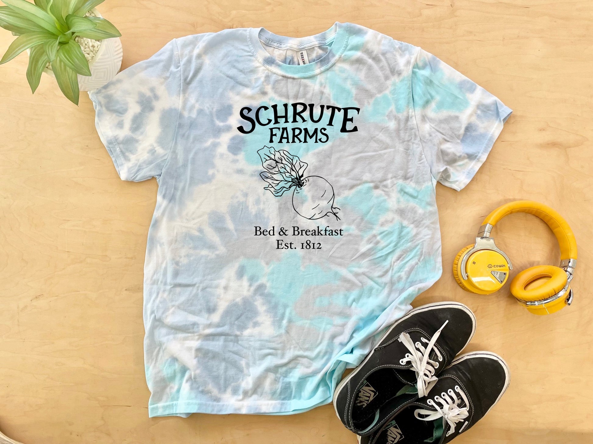 a t - shirt with the words schrute farms on it next to head