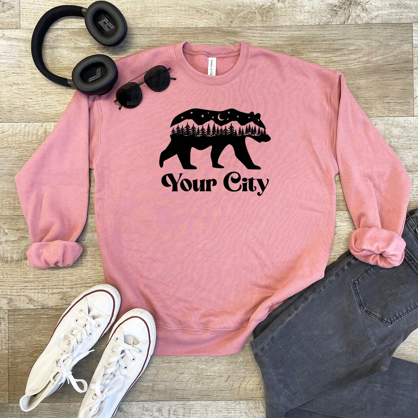 a pink sweatshirt with a bear and trees on it