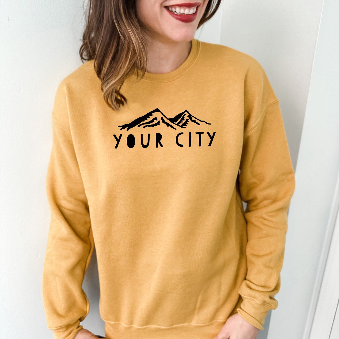 a woman wearing a yellow sweatshirt that says your city