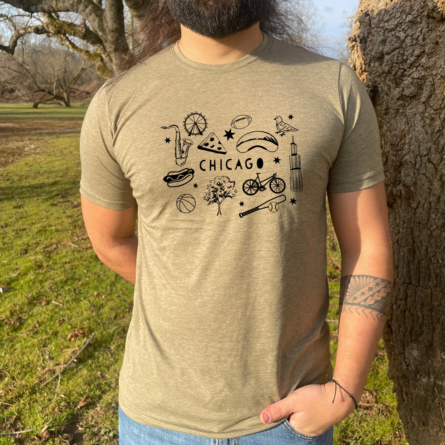 a man standing next to a tree wearing a chicago t - shirt