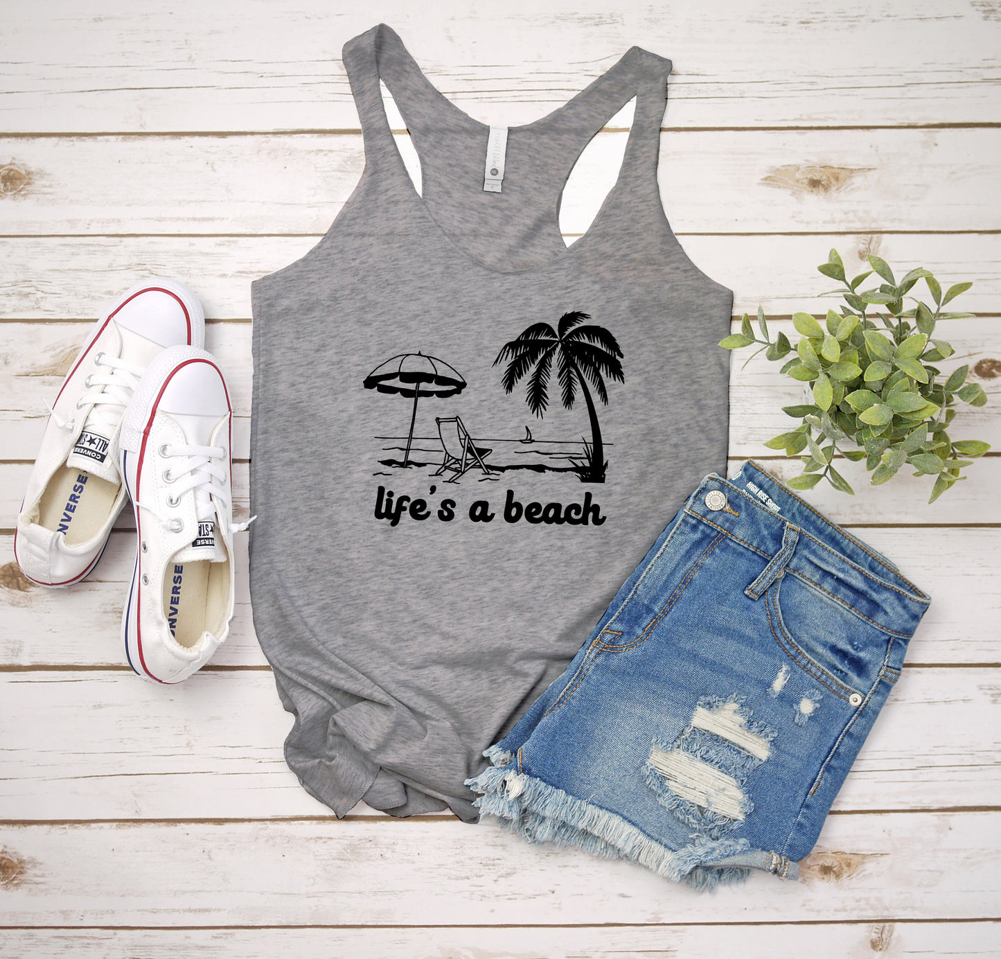 a tank top that says life's a beach next to a pair of shorts