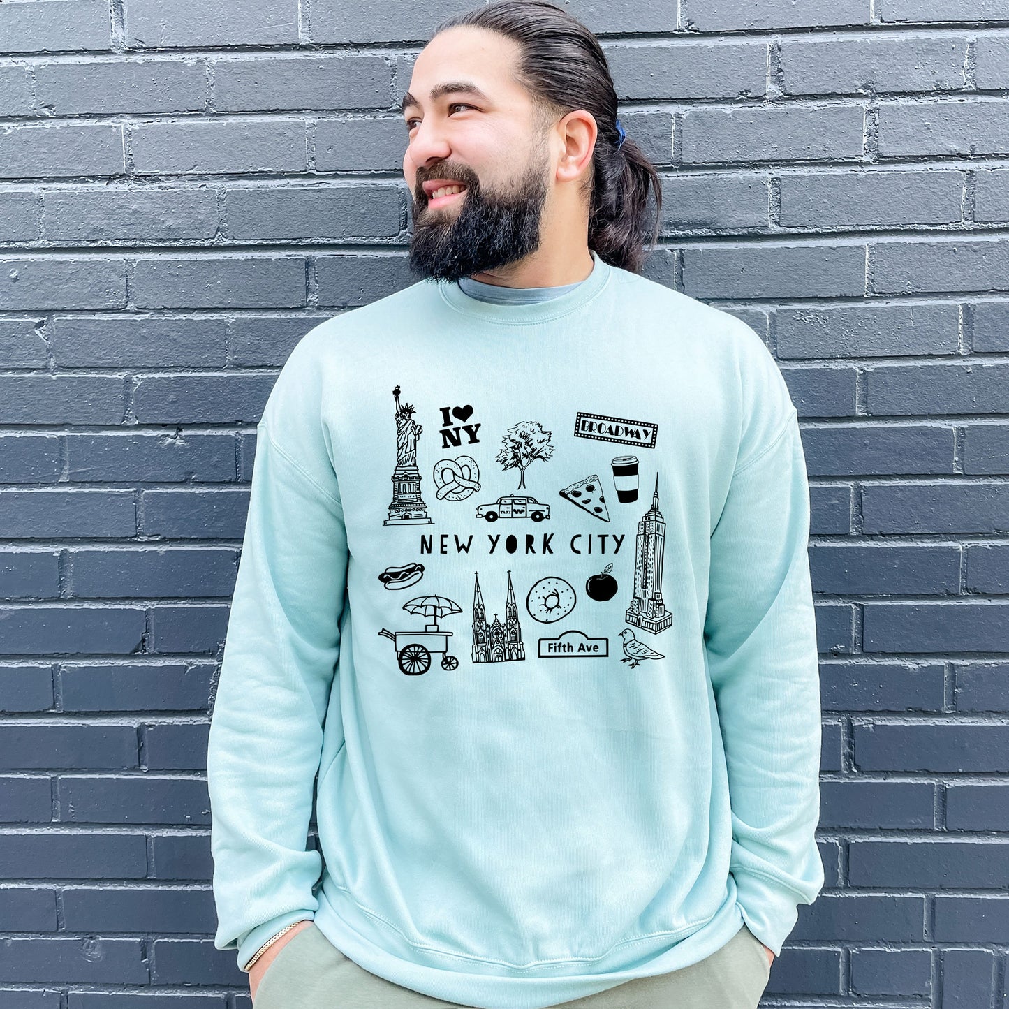 a man with a beard wearing a blue new york city sweatshirt