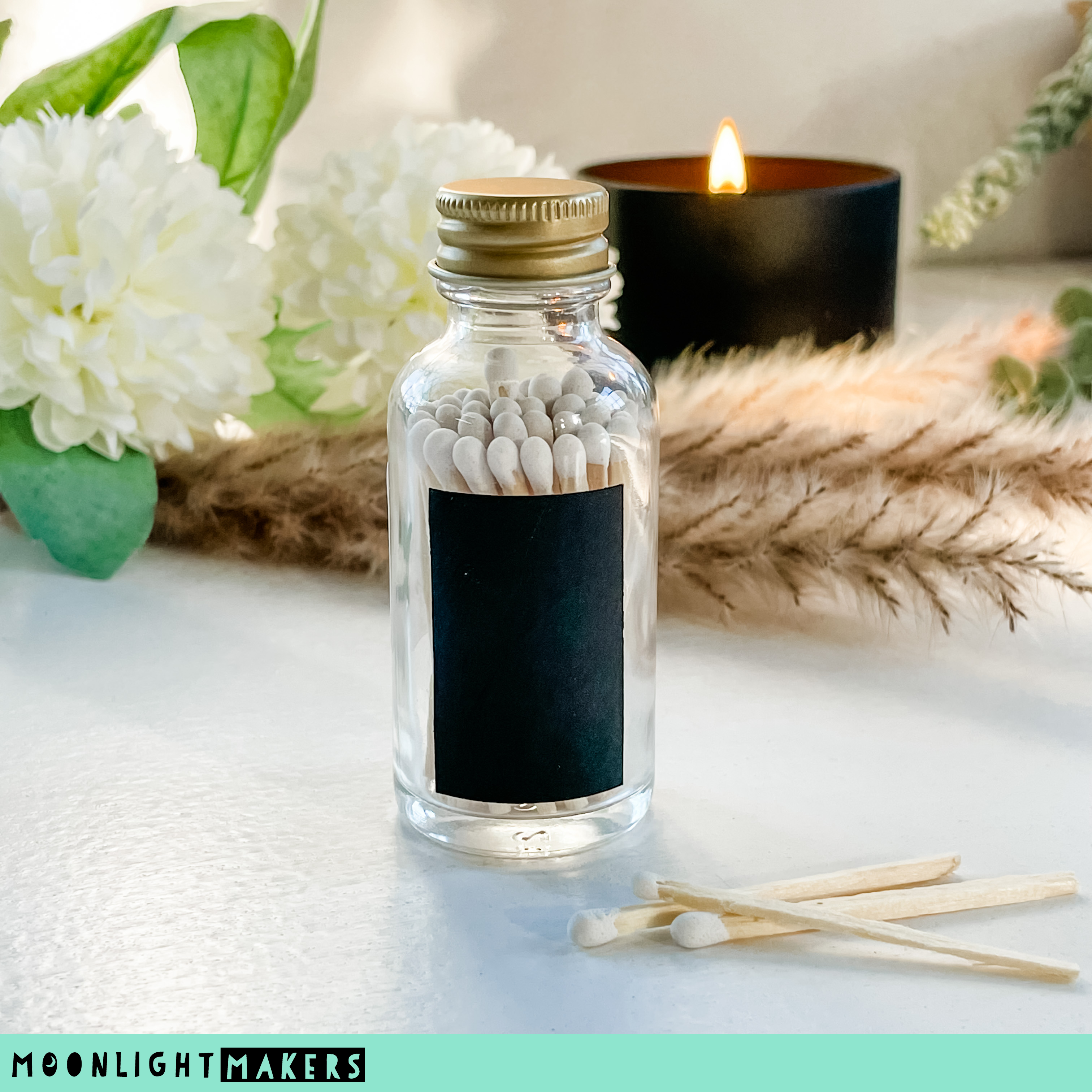a glass bottle filled with white pills next to a candle