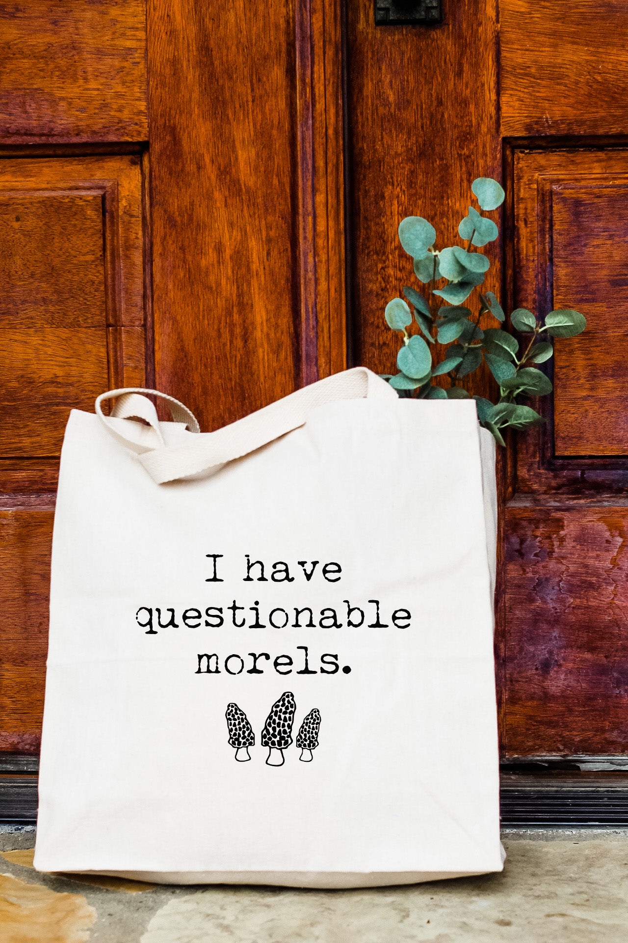 a tote bag sitting in front of a wooden door