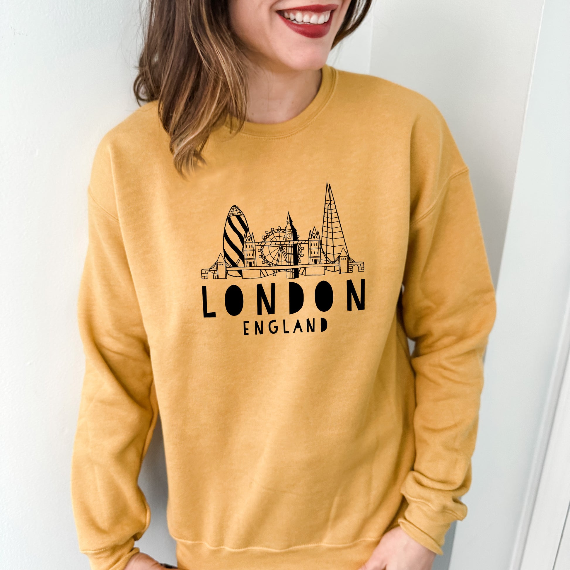 a woman wearing a yellow london england sweatshirt