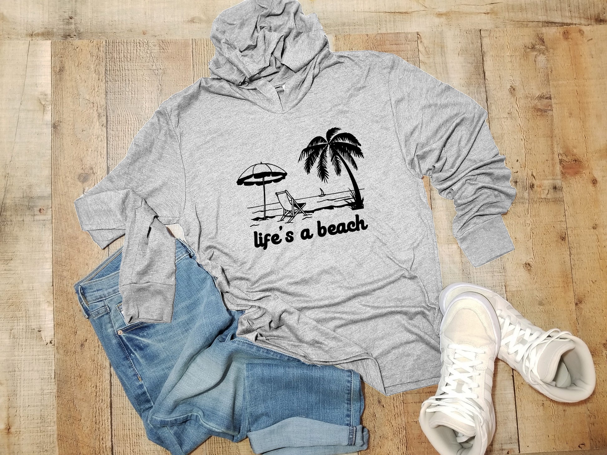 a hoodie that says life's a beach next to a pair of jeans