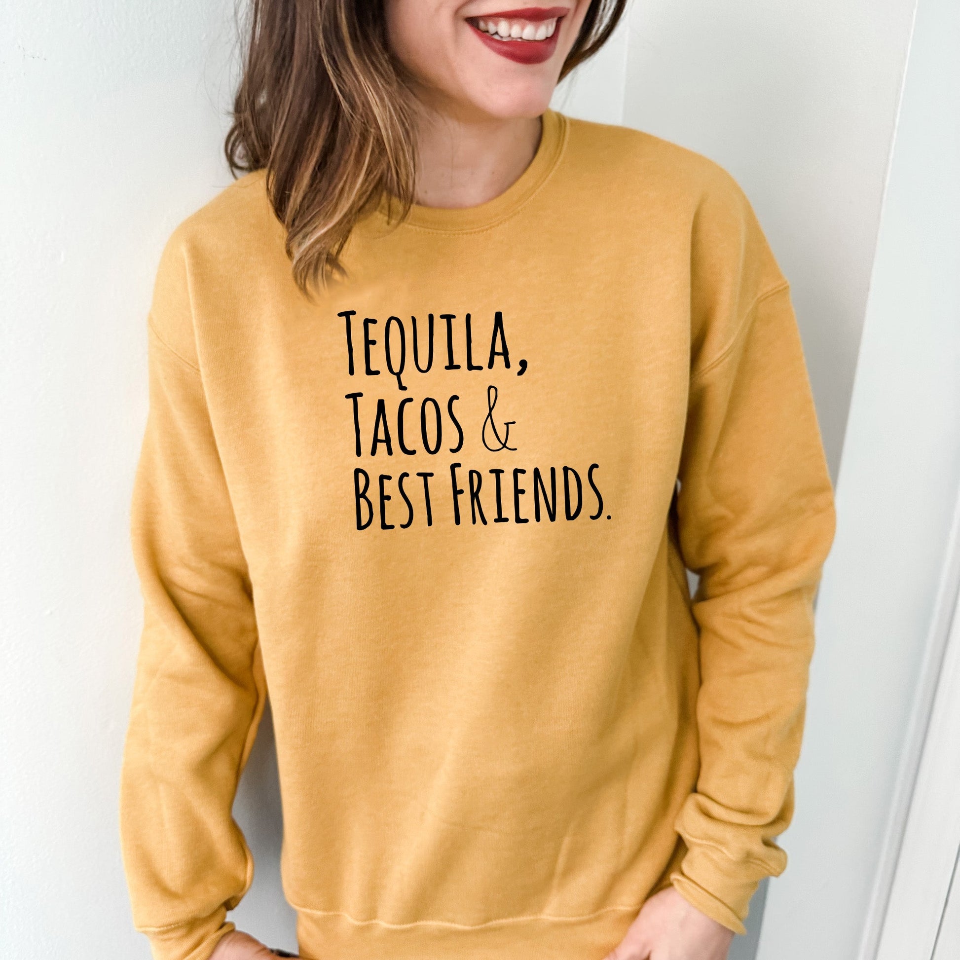 a woman wearing a sweatshirt that says tequila, tacos and best friends