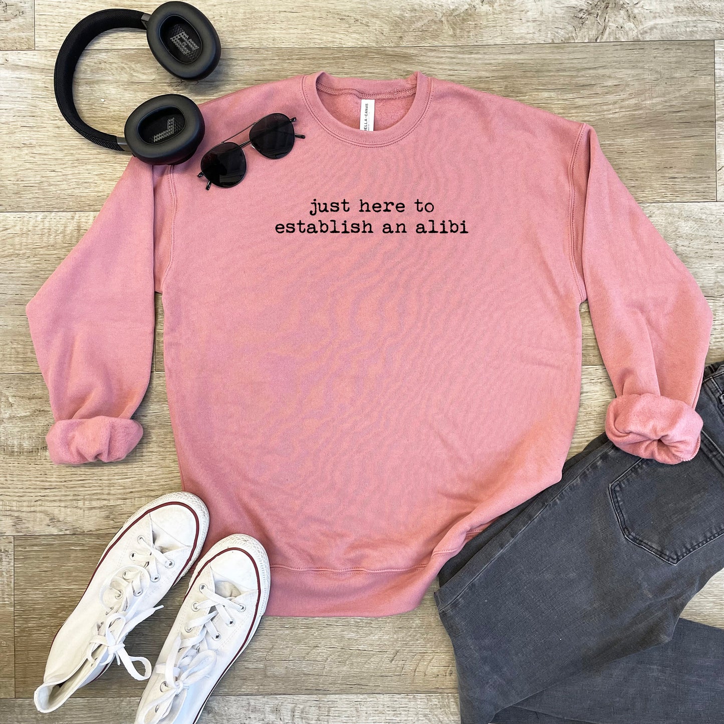 a pink sweatshirt with a pair of headphones and a pair of black headphones